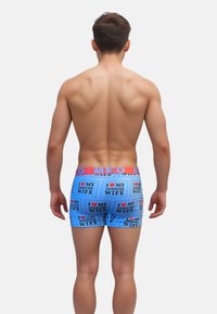 Calzoncillos de hombre en azul claro con un patrón de cajas de texto que dice "AMO A MI MARAVILLOSA ESPOSA". Cintura elástica en rojo contrastante.