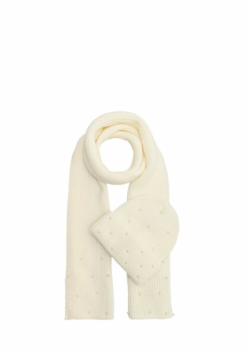 Zestaw czapki i szalika z dzianiny w kolorze kremowym, z teksturowanym wzorem z małymi, dekoracyjnymi białymi koralikami. Szalik jest długi i prostokątny, czapka ma zaokrąglony kształt.