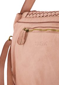 Lyserød lædertaske med vævede detaljer, en lynlåslomme med guldfarvet hardware og et præget brandlogo. Overfladen har en glat tekstur.