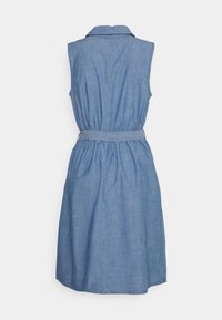 Lichtblauwe chambray-jurk met een kraag, mouwloze ontwerp, getailleerde taille en ceintuurdetail, vallend tot halverwege de dij. Soepele textuur.