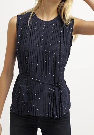 Top sin mangas de color azul marino con pliegues verticales, lunares blancos y una cinturilla atada para un ajuste ceñido. Tela suave y ligera.