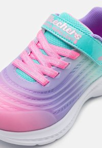 Baskets Skechers déperlant avec un design dégradé en violet, rose et turquoise, un dessus en maille texturée et des lacets roses.