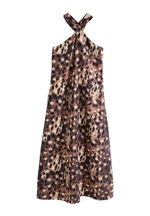Kvinde iført lang, ærmeløs maxikjole med leopardprint, sorte sandaler og store mørke solbriller, stående mod en beige baggrund.