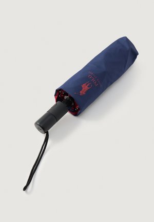Ombrello compatto di colore blu navy con manico nero, dotato di un interno rosso e un logo del marchio sulla custodia. Texture liscia e design leggero.