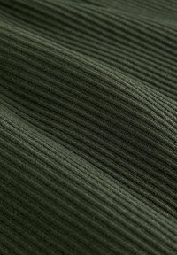 Dunkelgrüner, gerippter Stoff mit strukturierter Oberfläche und parallelen Linien, der einen sanften Glanz und ein robustes Material zeigt.