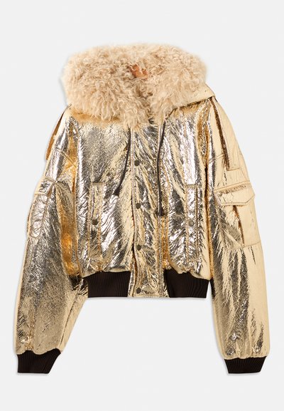 Metalen gouden bomberjack met een fluffy beige nepbontkraag, ribgebreide manchetten en meerdere frontzakken. Gladde, glanzende textuur.