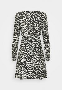 Svart klänning med långa ärmar, prydd med ett vitt abstrakt prickmönster. Midjan är markerad, med samlade ärmar och en utsvängd kjol.