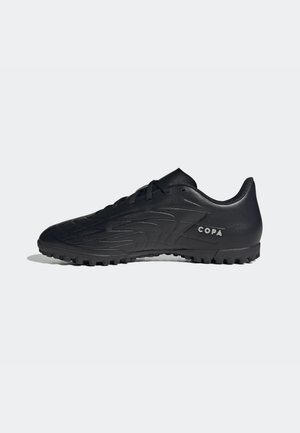 Chaussure de football noire basse avec dessus texturé, lacets, semelle en caoutchouc à crampons et texte "COPA" sur le côté sur fond blanc.