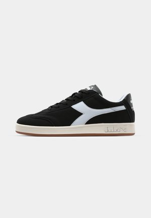 Zwarte sportieve sneakers met een witte diagonale streep, gestructureerde stof, ronde neus en rubberen zool. Voorzien van een logo op de tong en de zijkant.