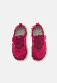 Chaussures en tricot rose avec deux sangles Velcro, bout rond, col rembourré et semelle en caoutchouc ; tige texturée avec des accents plus foncés contrastants.