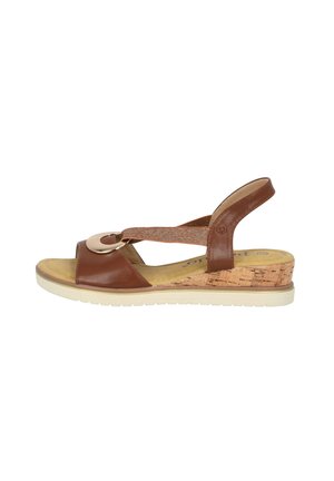 Brown leather slingback sandal with a round metal accent, cork wedge heel, and textured elastic strap, featuring a cushioned insole.