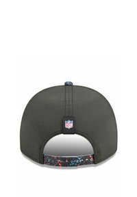 Schwarze Kappe aus perforiertem Stoff, verstellbarer Riemen mit einem mehrfarbigen Spritzmuster und NFL-Logo-Patch über dem Riemen.