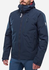 Navy waterproof jacket with a high collar, adjustable hood, and zippered front pockets. Features elastic cuffs and logo accents.