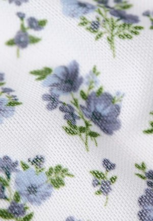 Witte gestructureerde stof met kleine clusters van lichtpaarse bloemen en groene bladeren, gedrukt in een herhalend patroon.