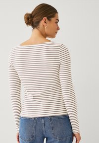 T-shirt à manches longues en tissu côtelé avec des rayures horizontales beiges et marron foncé, doté d'une encolure carrée et d'une silhouette ajustée.