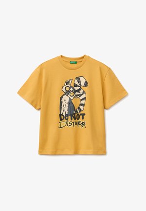 T-shirt giallo senape con illustrazione di lemure in stile cartone animato e scritta "NON DISTURBARE" stampata sul davanti.