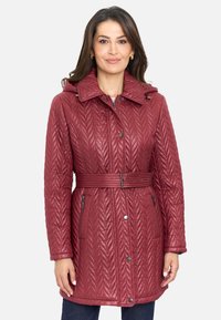 Abrigo burdeos acolchado con capucha, cintura ceñida y bolsillos con cremallera. Presenta un patrón en forma de chevrón y botones a presión. Textura suave.