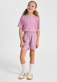 Lichtpaars T-shirt met korte mouwen en kleine witte patronen, gecombineerd met bijpassende korte broek, witte sokken en beige sneakers met zwarte accenten.