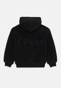 Juodas flisinis džemperis su tekstūru, turi gobtuvą ir nertus rankogalvius. Nugaros pusėje yra įspaustas „GUESS“ logotipas.