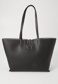Black leather tote bag with a textured finish, featuring a logo emblem in the center and contrasting stitching. Two long handles for carrying.