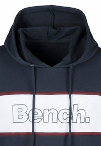 Dunkelblauer Hoodie mit Kordelzügen, ausgestattet mit einem weißen Bereich mit roten Streifen und dem Wort "Bench." in fetter grauer Schrift über der Brust.