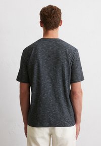 Kurzärmliges T-Shirt mit Rundhalsausschnitt in Dunkelgrau mit einem strukturierten, melierten Muster. Der Stoff wirkt weich und leicht.