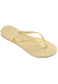 Gul gummiflip-flop med teksturert såle, smale V-formede stropper og en avrundet fotseng. Har en logo på innersålen.