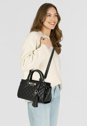 Schwarze, gesteppte Handtasche mit zwei Griffen und abnehmbarem Schulterriemen. Verziert mit goldfarbenen Beschlägen und einem Quastenanhänger.