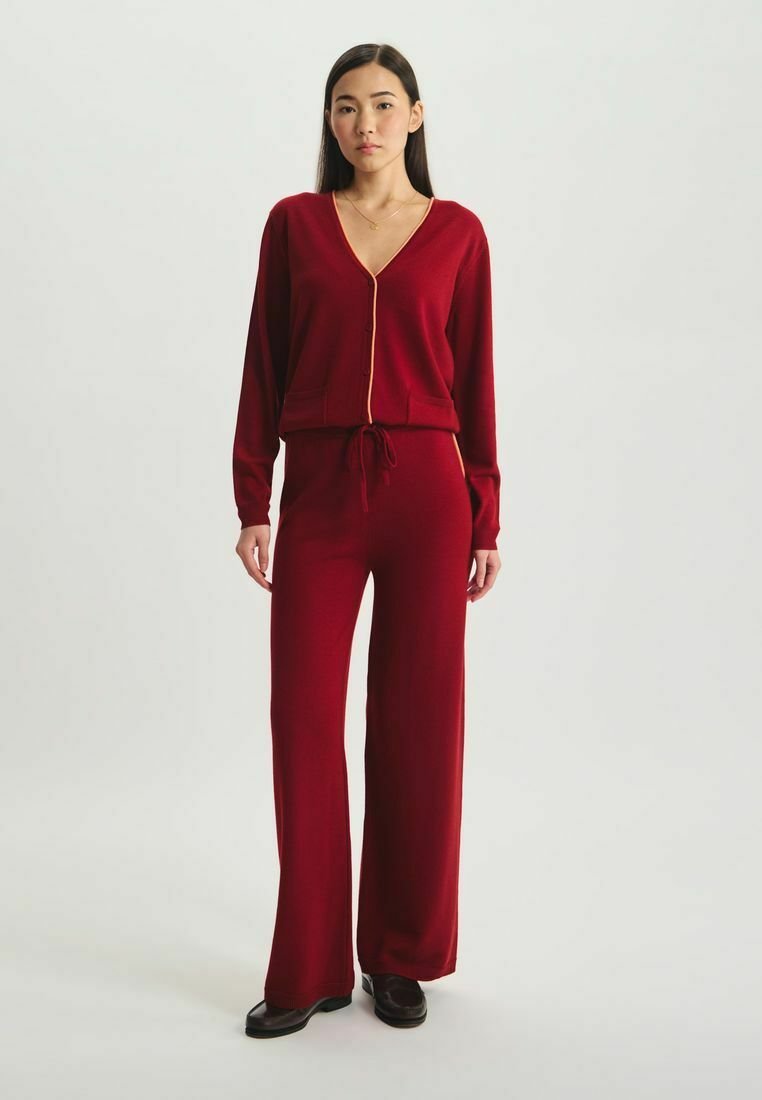 Ensemble bicolore cramoisi comprenant un haut à manches longues en V avec fermeture éclair et un pantalon large, confectionné dans un tissu doux au toucher lisse.