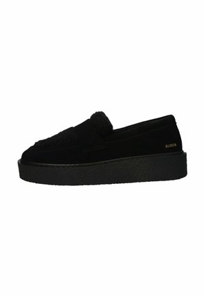 Black slip-on shoe with thick textured platform sole, suede and fuzzy upper, and small gold "BLOXSTN" logo near heel.