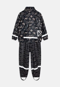Black waterproof rain jacket and pants with a marine pattern in beige, reflective accents, elastic cuffs, and ankle loops for secure fit.