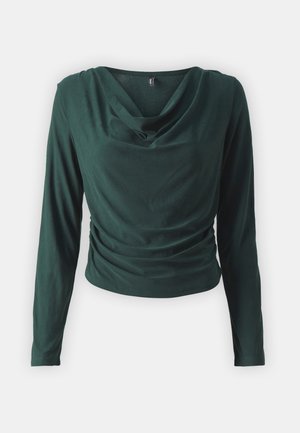 Mörkgrön långärmad topp med draperad halsringning och samlad detalj vid midjan, tillverkad av mjukt, slätt tyg.