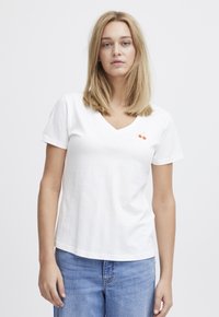 Weißes Baumwoll-T-Shirt mit V-Ausschnitt, kurzen Ärmeln und einem kleinen gestickten Design von zwei roten Kirschen auf der linken Brustseite.