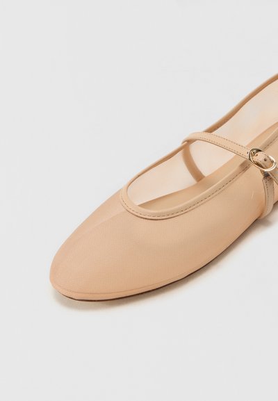 Beige flat ballet shoe with a textured fabric upper, pointed toe, and a thin ankle strap featuring a decorative gold buckle.