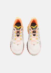 Laufschuhe mit einem weißen Mesh-Obermaterial, leuchtend orangefarbenen Akzenten, schwarzen und grünen Details sowie einer robusten Außensohle mit lebendigen Laufflächen.