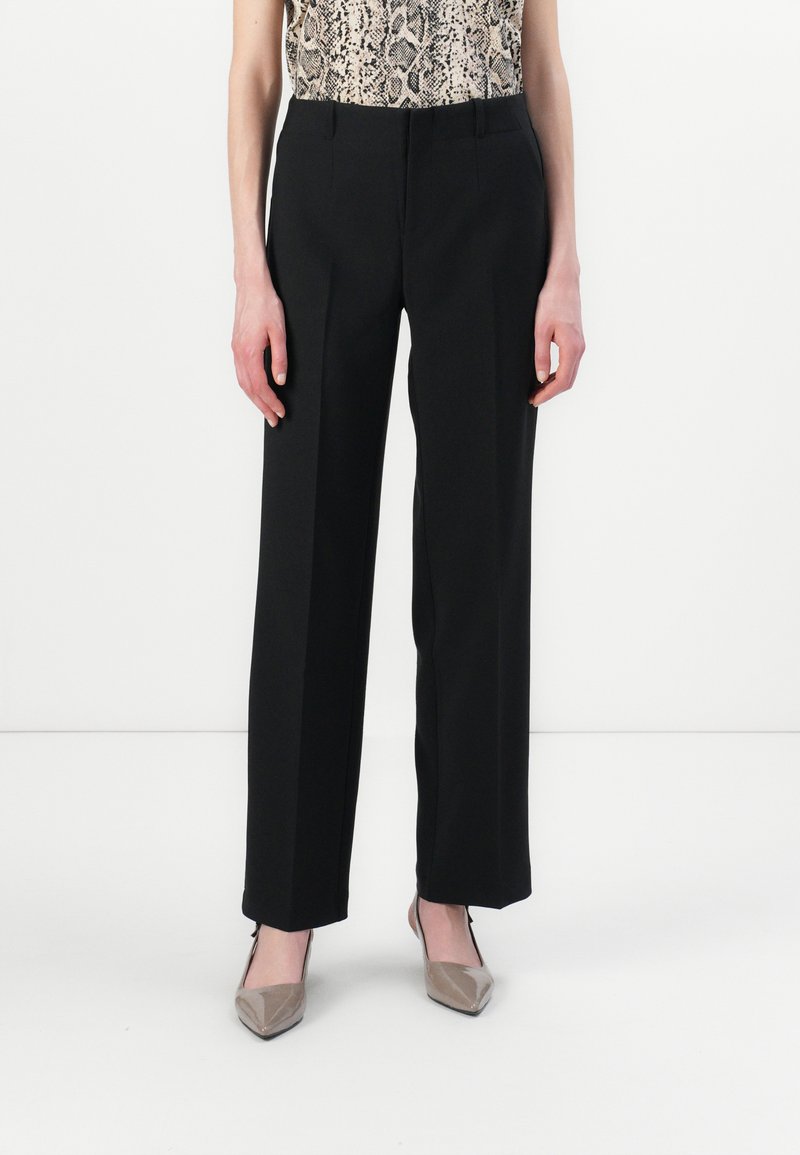 Black wide-leg trousers with a smooth texture, featuring front pleats. Paired with a snake print top and neutral pointed-toe heels.