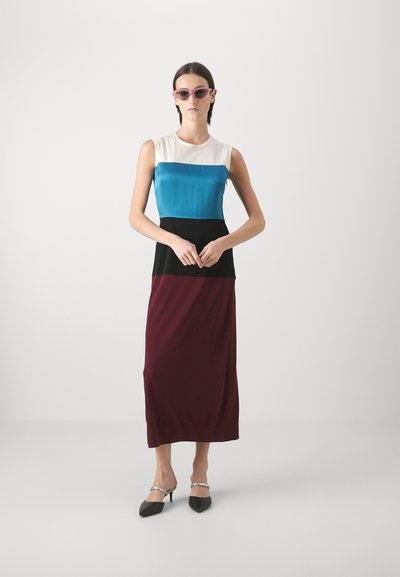 Rochie fără mâneci cu blocuri de culoare, design alb, teal, negru și bordo; material neted; model purtând ochelari de soare roz și tocuri negre.