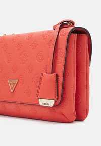 Rødt tekstureret læderhåndtaske med præget logo mønster, trekantet metal logo plade og kontrasterende sort kant.