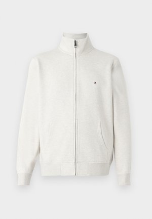 Giacca in pile grigia chiara con zip, colletto rialzato, tasche frontali, maniche lunghe e piccolo logo sul petto sinistro.