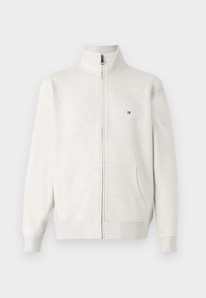 Helle graue Fleecejacke mit Reißverschluss, Stehkragen, vorderen Taschen, langen Ärmeln und kleinem Logo auf der linken Brust.