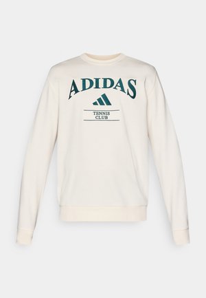 Grietos spalvos džemperis su apykakle, kuriame yra žalias "ADIDAS" tekstas ir "TENNIS CLUB" po juo, su raštuotais rankogaliais ir tiesia apačia.