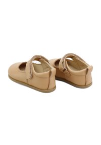 Zapatos Mary Jane de cuero marrón con puntera redonda, un diseño recortado y una correa de Velcro. Textura suave y suela plana de goma.