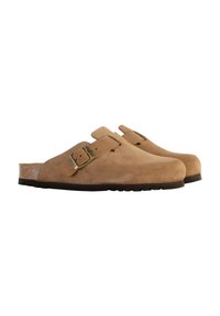 Le zoccoli in suede color sabbia presentano una punta arrotondata, una cinghia regolabile con fibbia in ottone e un plantare in sughero naturale con una suola in gomma testurizzata.