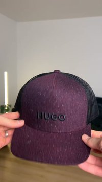 Șapcă mov cu partea din față din țesătură texturată, spate din plasă neagră și sigla "HUGO" în relief pe partea din față. Vizieră curbată cu materiale în contrast.