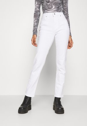 Witte rechte jeans van denim, met een hoge taille, voorzakken en een platte metalen knoop, gecombineerd met zwarte veterschoenen op een platform.