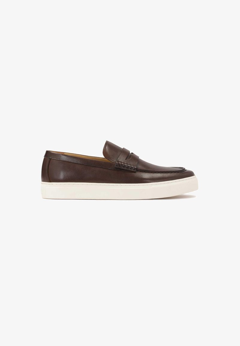 Zapato marrón de piel tipo slip-on con un acento trenzado en el empeine y una suela de goma blanca. Presenta una punta redondeada y un acabado suave.