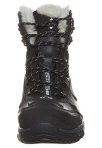 Bota negra impermeable con cuello de pelo sintético, parte superior texturizada y cordones en contraste. Diseño ergonómico con una suela de goma gruesa para mayor tracción.