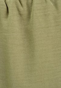Tissu texturé de couleur vert olive clair, présentant une surface lisse avec des variations subtiles de ton et de profondeur, rassemblé en haut.