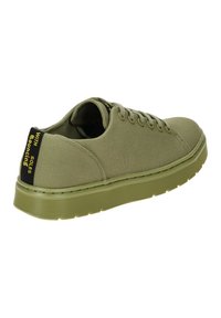 Sneaker verde oliva con tomaia in tela, punta rotonda e suola in gomma spessa; presenta un supporto sul tallone nero con testo giallo e cuciture tonali.