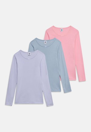 Drei langärmelige Mädchenshirts in Pastelllila, Blau und Rosa, jeweils mit einer kleinen Schleife am Ausschnitt und runden Kragen.